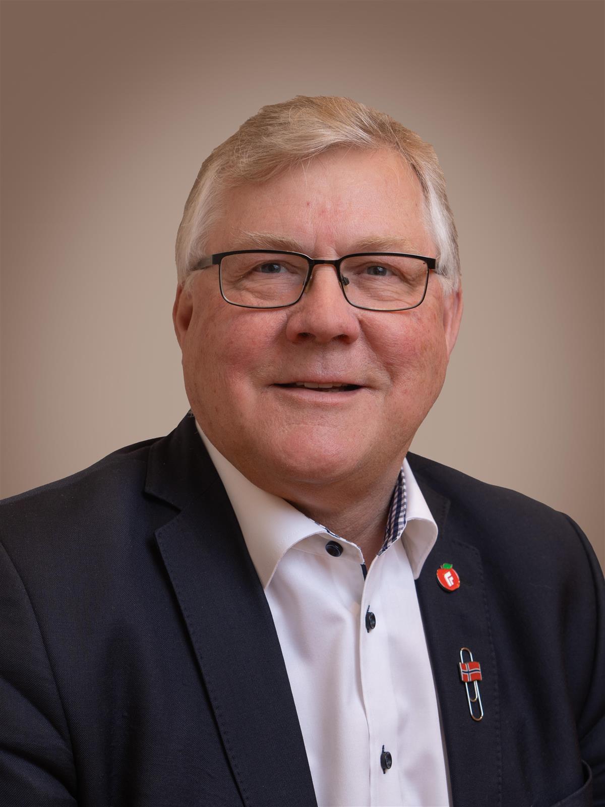 Portrett av mann i mørk dressjakke og briller - Klikk for stort bilete